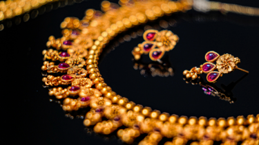 gold necklace and earrings with red gemstones