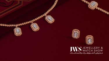 18-karat rose gold bracelet, necklace, and earrings laid down on a red surface 