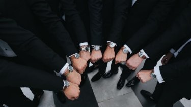 A group of man wearing watches