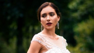 Bride wearing gown with high neckline and a pair of hanging earrings