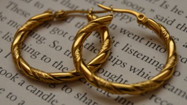 Gold hoop earrings on a book page