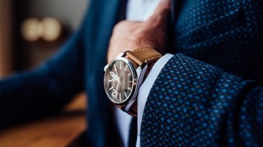 Man in formal suit shows wrist watch