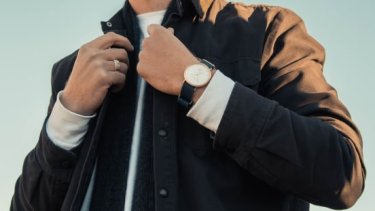 Man showing off watch while holding jacket