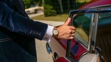 Man wearing watch opening car door