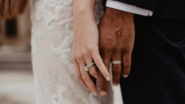 Two persons wearing silver colored rings