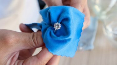 Diamond ring being cleaned with blue cloth
