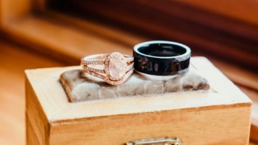 rose gold ring and metal ring on a wooden box