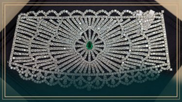 An image of necklace with green gem at the center